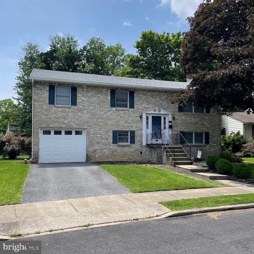 32 Edgelea Dr, Chambersburg, PA 17201 - bi-level home with an attached garage, driveway, a front lawn, and brick siding