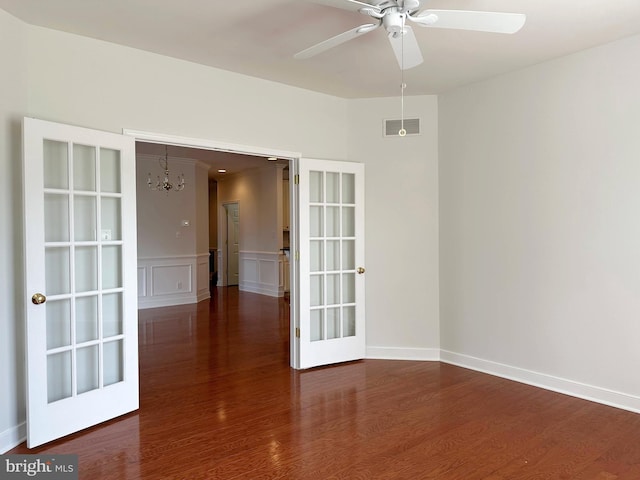 1039 Burgundy Cir, Pennsburg, PA 18073 - unfurnished room featuring a chandelier, wood finished floors, ceiling fan, a wainscoted wall, and a decorative wall