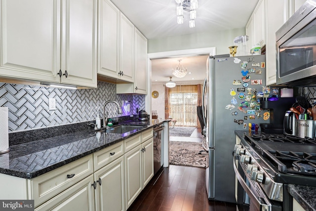 2203 Pyle St, Wilmington, DE 19805 - kitchen with stainless steel appliances, decorative backsplash, dark wood finished floors, dark stone countertops, and white cabinets
