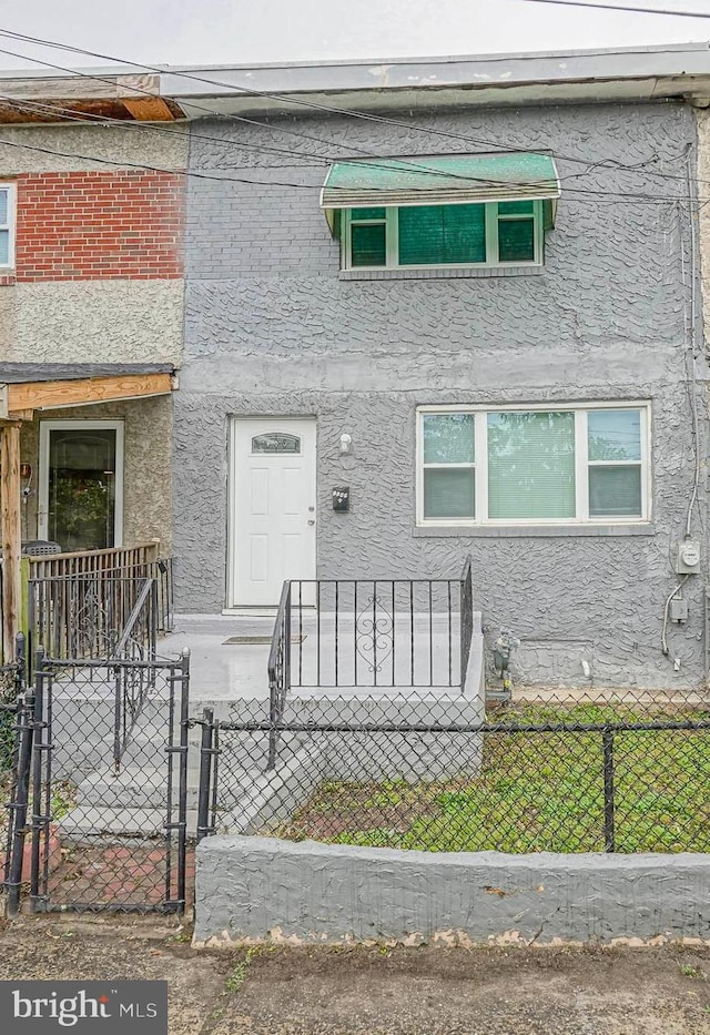 1549 S 8th St, Camden, NJ 08104 - view of front of property with a fenced front yard, stucco siding, and a gate