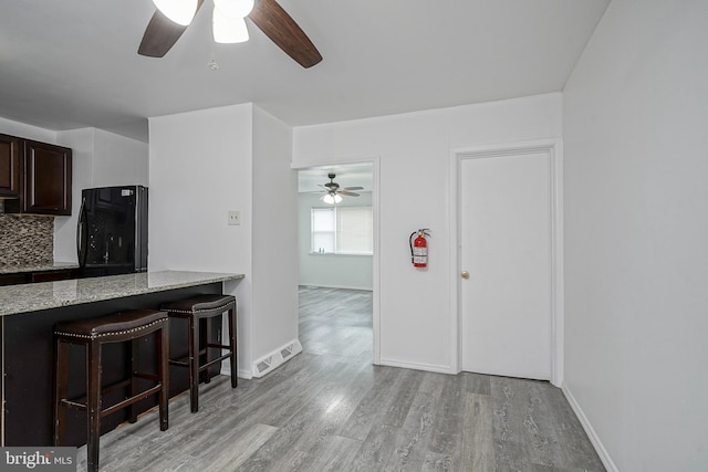 1549 S 8th St, Camden, NJ 08104 - kitchen featuring a ceiling fan, light wood finished floors, a breakfast bar area, and refrigerator