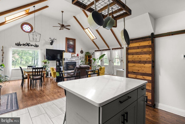 206 English Muffin Ct, Berkeley Springs, WV 25411 - kitchen with ceiling fan, a skylight, a kitchen island, light countertops, and high vaulted ceiling