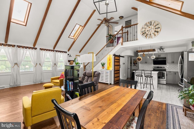 206 English Muffin Ct, Berkeley Springs, WV 25411 - dining space featuring a skylight, high vaulted ceiling, a ceiling fan, beam ceiling, and stairs