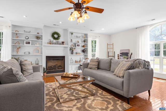 366 Saint Ivy Ave, Troy, VA 22974 - living area with wood finished floors, a ceiling fan, a glass covered fireplace, built in features, and recessed lighting