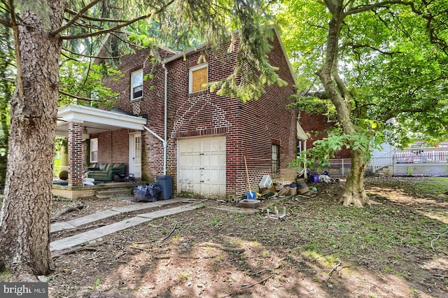 1220 N 14th St, Harrisburg, PA 17103 - view of side of home featuring brick siding, an attached garage, and driveway
