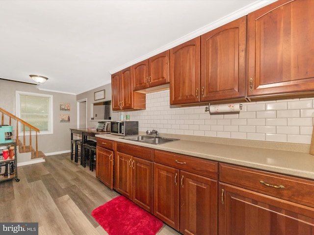 12535 Rockdale Rd, Clear Spring, MD 21722 - kitchen featuring backsplash, crown molding, light countertops, wood finished floors, and stainless steel microwave