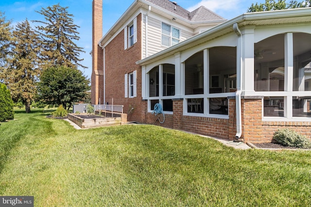 3950 Island Crk, Broomes Island, MD 20615 - view of home's exterior featuring brick siding, a sunroom, a chimney, and a lawn