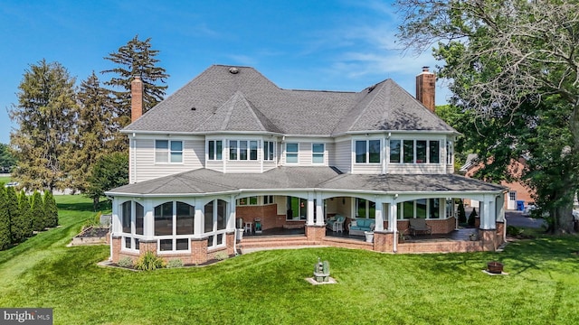 3950 Island Crk, Broomes Island, MD 20615 - rear view of house featuring brick siding, a lawn, a chimney, and a sunroom