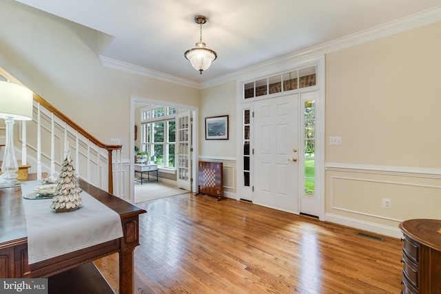 3950 Island Crk, Broomes Island, MD 20615 - entryway featuring stairway, crown molding, light wood-type flooring, and a wainscoted wall