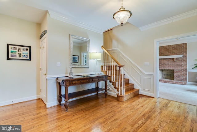 3950 Island Crk, Broomes Island, MD 20615 - stairway featuring wood finished floors, a brick fireplace, and crown molding