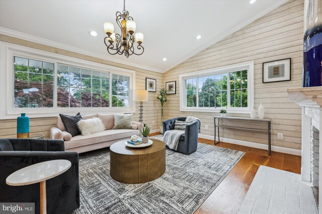 11218 Monticello Ave, Silver Spring, MD 20902 - living room featuring vaulted ceiling, wood walls, wood finished floors, crown molding, and a chandelier