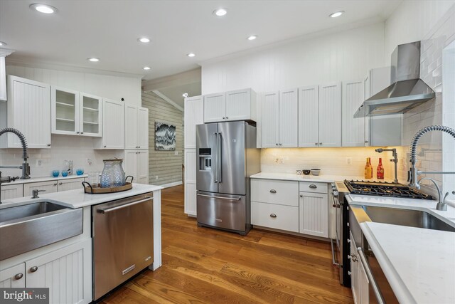 11218 Monticello Ave, Silver Spring, MD 20902 - kitchen with stainless steel appliances, wall chimney exhaust hood, wood finished floors, vaulted ceiling, and backsplash