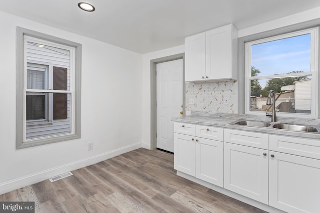 218 Sewell Ave, Hamilton, NJ 08610 - kitchen featuring a sink, baseboards, backsplash, white cabinetry, and light wood-style floors