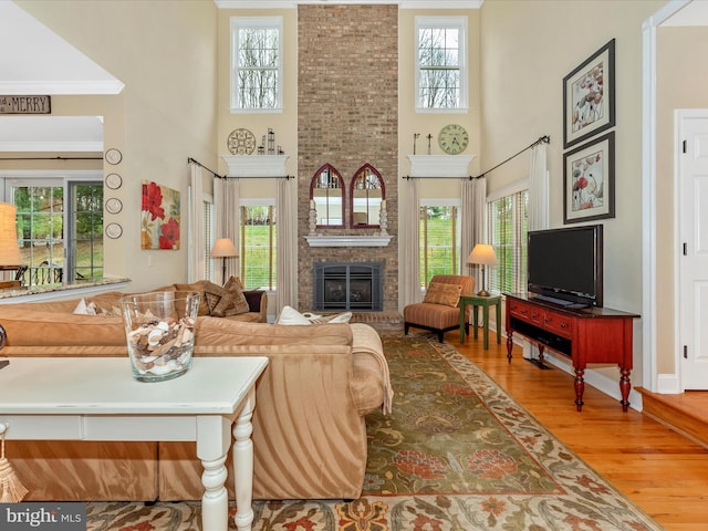 22324 Canterfield Way, Germantown, MD 20876 - living room featuring a towering ceiling, wood finished floors, a fireplace, and crown molding