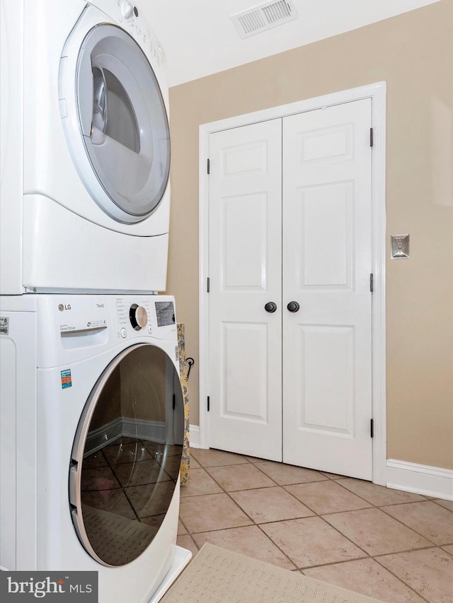 22324 Canterfield Way, Germantown, MD 20876 - washroom featuring stacked washer / drying machine, baseboards, and light tile patterned floors