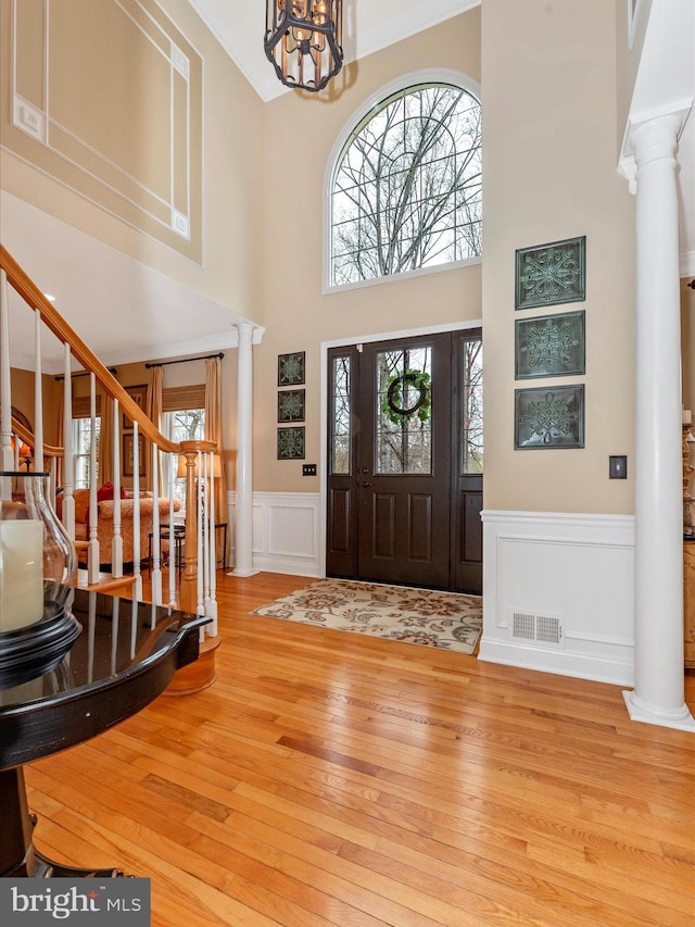 22324 Canterfield Way, Germantown, MD 20876 - entryway featuring ornate columns, wood-type flooring, a decorative wall, a high ceiling, and a wainscoted wall