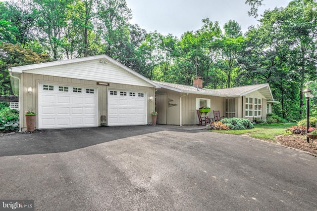1534 Benton Hollow Rd, Drumore, PA 17518 - ranch-style home featuring a chimney, asphalt driveway, a garage, and view of scattered trees