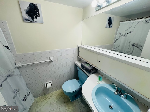 46 Township Line Rd Unit 215, Elkins Park, PA 19027 - bathroom featuring a sink, marble finish flooring, toilet, tile walls, and a wainscoted wall