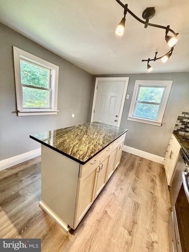1946 Dennie St, Philadelphia, PA 19140 - kitchen featuring baseboards, light wood-type flooring, dark stone countertops, and a kitchen island