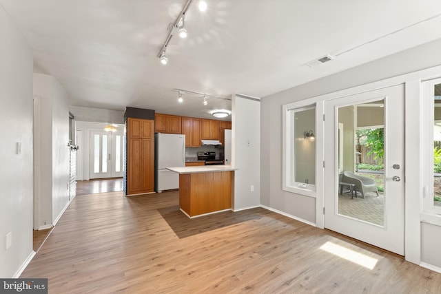 402 Sugarland Run Dr, Sterling, VA 20164 - kitchen with freestanding refrigerator, rail lighting, under cabinet range hood, brown cabinets, and range with electric stovetop