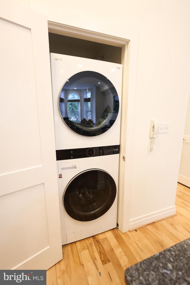 1622 19th St NW Unit 2, Washington, DC 20009 - laundry area featuring estacked washer and dryer, wood finished floors, and a heating unit