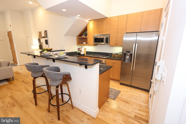 1622 19th St NW Unit 2, Washington, DC 20009 - kitchen featuring appliances with stainless steel finishes, a breakfast bar area, light wood-style floors, recessed lighting, and open shelves