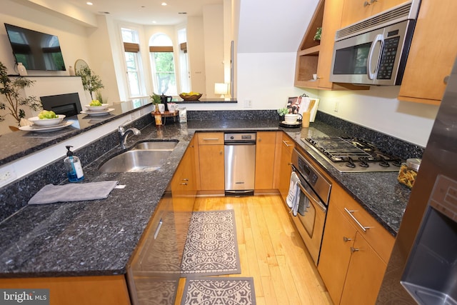 1622 19th St NW Unit 2, Washington, DC 20009 - kitchen with stainless steel appliances, light wood-style flooring, dark stone counters, recessed lighting, and a fireplace