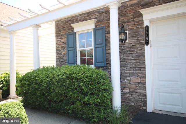 44497 Maltese Falcon Sq, Ashburn, VA 20147 - doorway to property featuring stone siding and covered porch