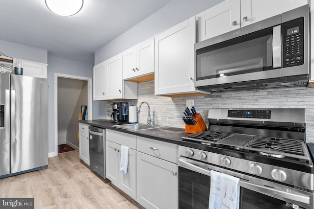 222 Blakeney Rd, Baltimore, MD 21228 - kitchen with appliances with stainless steel finishes, white cabinets, tasteful backsplash, and light wood-type flooring