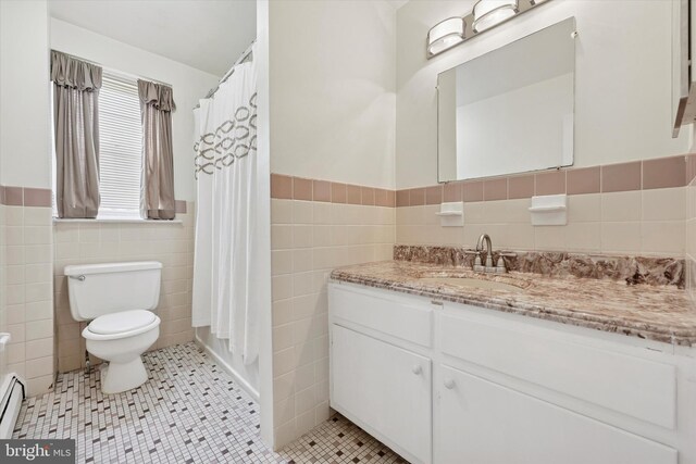 48 Llanfair Rd Unit 1, Ardmore, PA 19003 - full bathroom featuring tile walls, a baseboard heating unit, vanity, tile patterned flooring, and wainscoting