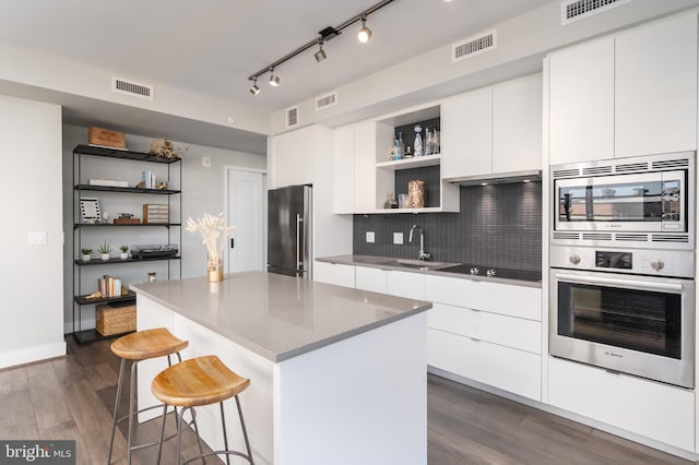 1300 4th St SE Unit 715, Washington, DC 20003 - kitchen with open shelves, appliances with stainless steel finishes, modern cabinets, a breakfast bar, and dark wood-style floors