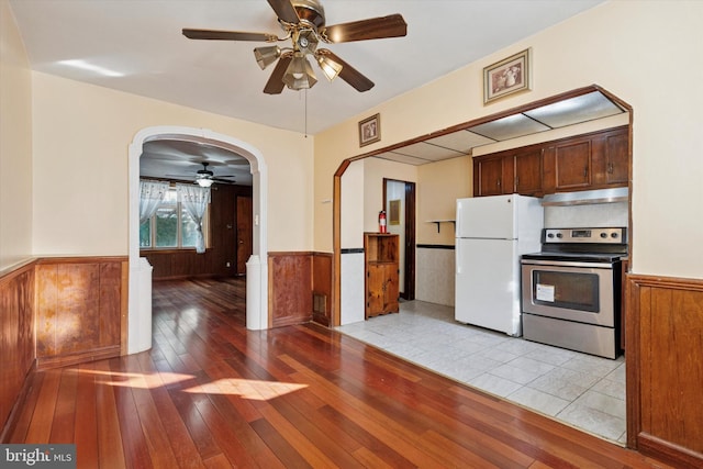 5450 Erdrick St, Philadelphia, PA 19124 - kitchen featuring freestanding refrigerator, stainless steel range with electric cooktop, under cabinet range hood, wainscoting, and a ceiling fan