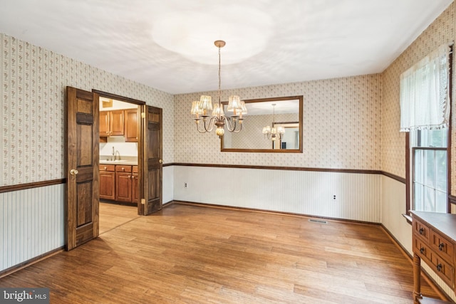 13 Plymouth, Tabernacle, NJ 08088 - unfurnished dining area with a chandelier, wallpapered walls, and light wood-type flooring