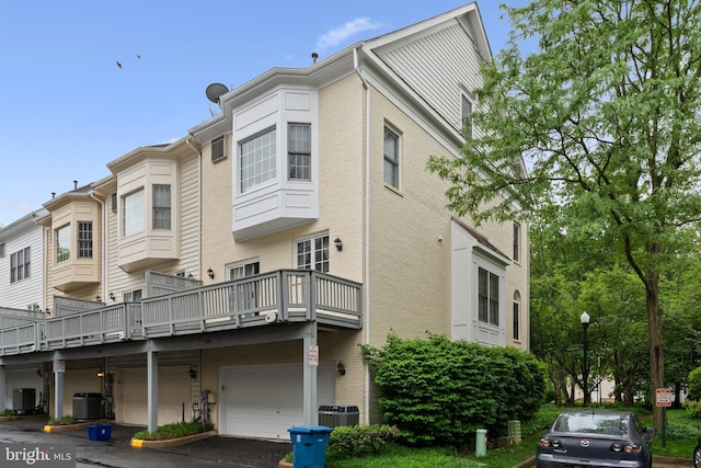 8878 Ashgrove House Ln, Vienna, VA 22182 - view of building exterior featuring a garage, central AC unit, and driveway