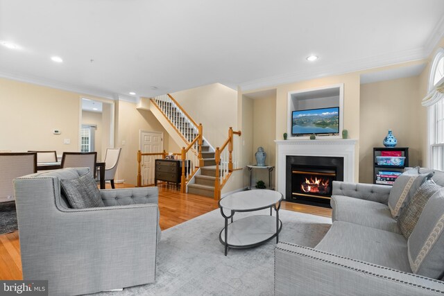 8878 Ashgrove House Ln, Vienna, VA 22182 - living area featuring stairway, a lit fireplace, light wood finished floors, ornamental molding, and recessed lighting