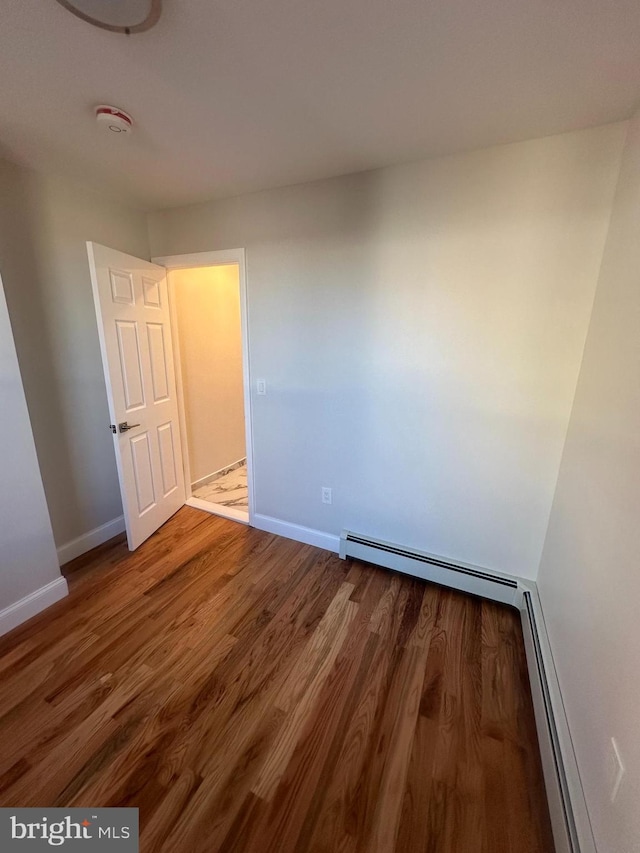 205 W Wishart St, Philadelphia, PA 19133 - empty room with wood finished floors, baseboards, a smoke detector, and a baseboard heating unit