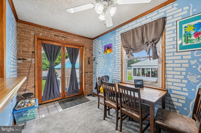 110 S Marlyn Ave, Essex, MD 21221 - tiled dining space with brick wall, ornamental molding, healthy amount of natural light, ceiling fan, and a textured ceiling