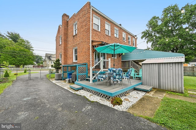 110 S Marlyn Ave, Essex, MD 21221 - rear view of house featuring brick siding, a deck, a gate, and a shed