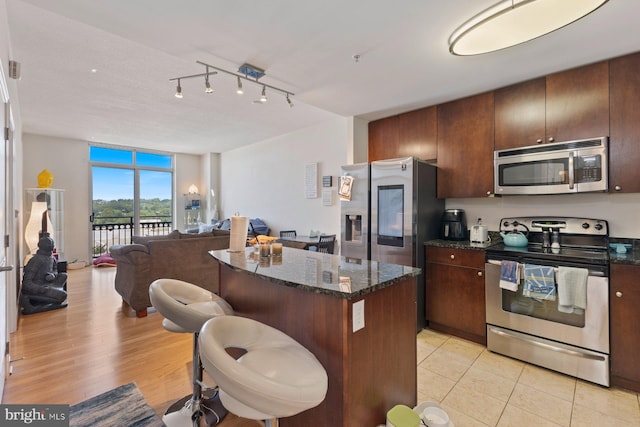 155 Potomac Psge Unit 817, Oxon Hill, MD 20745 - kitchen with stainless steel appliances, a center island, dark stone countertops, open floor plan, and a breakfast bar