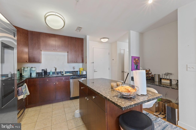 155 Potomac Psge Unit 817, Oxon Hill, MD 20745 - kitchen with dishwasher, a center island, light tile patterned flooring, dark stone counters, and a kitchen bar