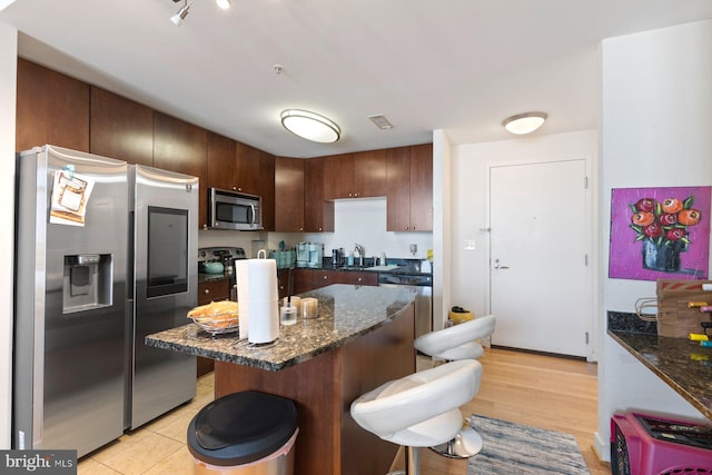 155 Potomac Psge Unit 817, Oxon Hill, MD 20745 - kitchen featuring stainless steel appliances, a breakfast bar area, dark stone counters, and a kitchen island