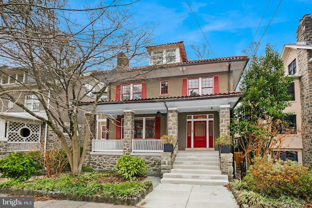 2950 Macomb St NW, Washington, DC 20008 - view of front of house with covered porch, stone siding, a tile roof, a chimney, and stucco siding