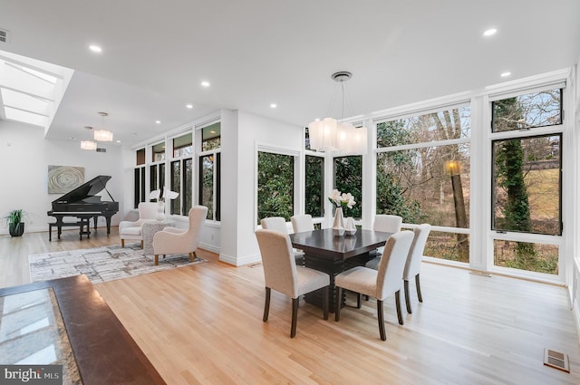 2950 Macomb St NW, Washington, DC 20008 - dining room featuring light wood finished floors, a skylight, recessed lighting, a chandelier, and baseboards
