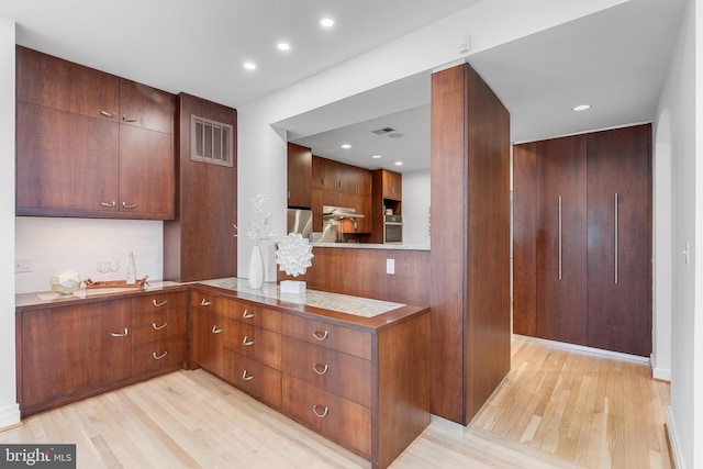 2950 Macomb St NW, Washington, DC 20008 - kitchen with light wood-type flooring, recessed lighting, and under cabinet range hood