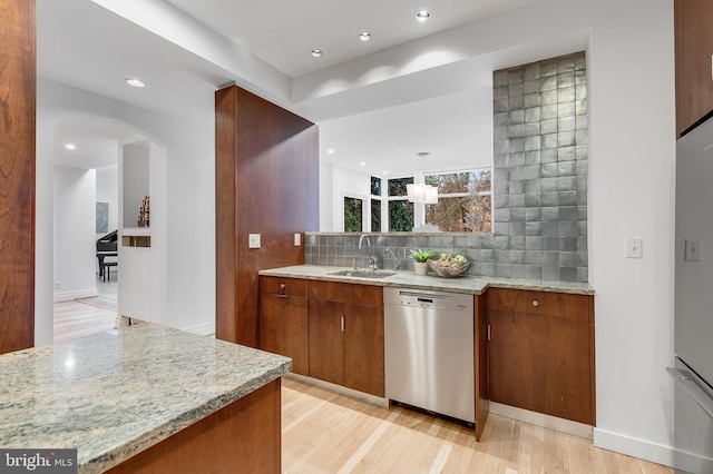 2950 Macomb St NW, Washington, DC 20008 - kitchen with dishwasher, a sink, arched walkways, backsplash, and light wood-type flooring