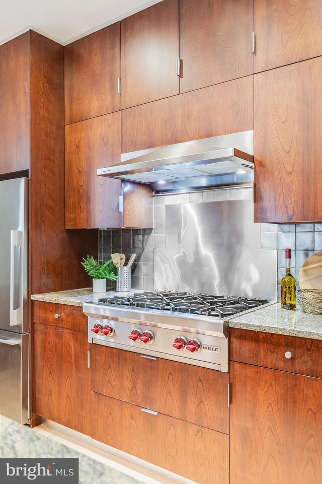 2950 Macomb St NW, Washington, DC 20008 - kitchen with stainless steel appliances, range hood, tasteful backsplash, and light stone countertops