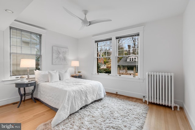 2950 Macomb St NW, Washington, DC 20008 - bedroom with radiator heating unit, wood finished floors, baseboards, and ceiling fan