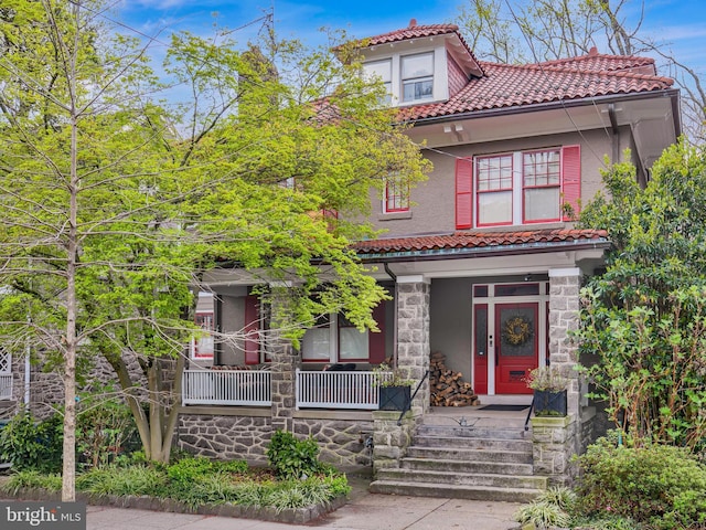 2950 Macomb St NW, Washington, DC 20008 - mediterranean / spanish house with a tile roof, a porch, stone siding, and stucco siding