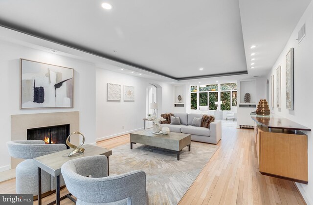 2950 Macomb St NW, Washington, DC 20008 - living room with arched walkways, a tray ceiling, recessed lighting, light wood-type flooring, and a high end fireplace
