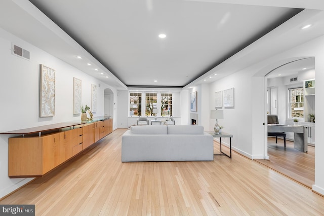 2950 Macomb St NW, Washington, DC 20008 - living area with arched walkways, recessed lighting, light wood-style floors, a desk, and baseboards